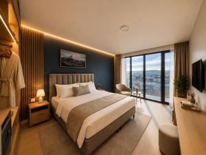 a bedroom with a large bed and a large window at Garslyan Boutique Hotel in Ninotsminda +1 photo
