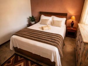 a bedroom with a large bed with white sheets and pillows at Villa Pella - Chalé Tulipa- com café manhã in Brumadinho +14 photos