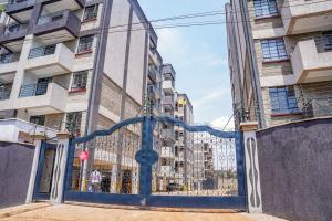 a blue gate in front of a building at Amaziah apartment Mimyhomes in Nairobi