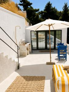 a patio with a table and an umbrella at THE HILL Suite in Ialysos