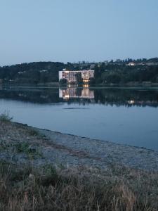 a building in the middle of a lake at Apartmany BlueWave Riverside Piešťany in Banka