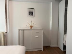 a white cabinet with a vase on it in a bedroom at Apartman Bor in Kiseljak