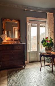 a bathroom with a dresser and a mirror and a table at B&B Dàmur in Piazza Armerina