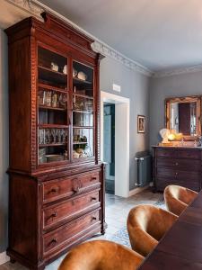 a large wooden cabinet in a living room with chairs at B&B Dàmur in Piazza Armerina +37 photos