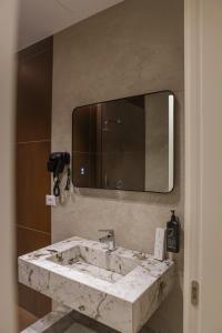 a bathroom with a marble sink and a mirror at Oribu Boutique Hotel Vlore in Vlorë