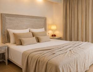 a bedroom with a large white bed with pillows at Christaras Apartments in Vourvourou