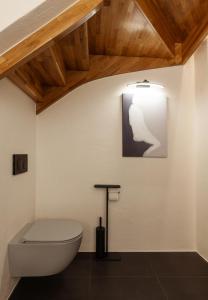 a bathroom with a white toilet and a wooden ceiling at Jannseni Premium Penthouse I Sauna I Free Parking in Pärnu