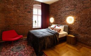 a bedroom with a bed and a brick wall at Jannseni Premium Penthouse I Sauna I Free Parking in Pärnu