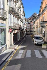 a white car parked on a street with buildings at Studio le Desman des Neiges - Hyper centre - Proche thermes et télécabine in Cauterets