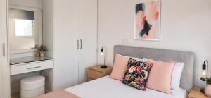 a small bedroom with a bed with a pink pillow at Nerina Townhouse By Staycom in Paphos