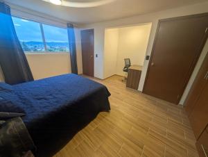 a bedroom with a bed and a large window at Casa Terraza Zacatlan in Zacatlán