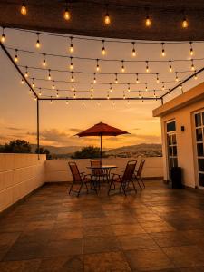 a patio with a table and chairs and lights at Casa Terraza Zacatlan in Zacatlán