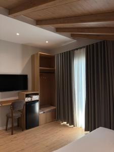 a hotel room with a bed and a desk and a television at Airport Gate Hotel in Rinas