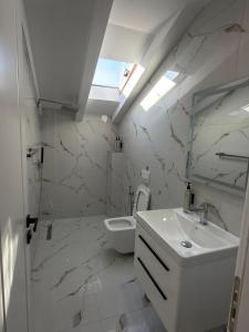 a white bathroom with a sink and a toilet at Airport Gate Hotel in Rinas +31 photos