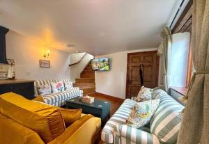 a living room with two couches and a table at Wind in the Willows Moreton in Marsh in Moreton in Marsh
