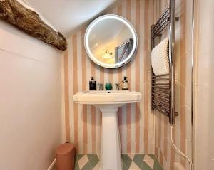 a bathroom with a sink and a mirror at Wind in the Willows Moreton in Marsh in Moreton in Marsh +42 photos