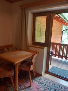 a wooden table and chairs in a room with a window at Bad Kalkstein in Innervillgraten