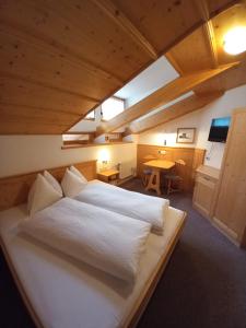 a large white bed in a room with a table at Bad Kalkstein in Innervillgraten