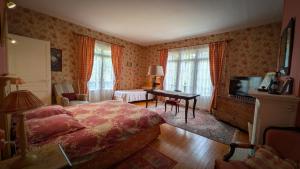 a bedroom with a bed and a desk and a television at Caux Loc' du Manoir in Graincourt