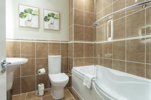 a bathroom with a toilet and a tub and a sink at The Tontine Hotel in Greenock +38 photos