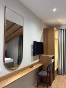 a room with a mirror and a desk and a bed at Airport Gate Hotel in Rinas