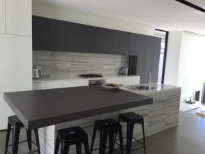 a kitchen with a black counter and stools in it at Phegans Bay Waterfront Haven in Blackwall
