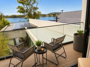two chairs and a table on a balcony with a view of the water at Phegans Bay Waterfront Haven in Blackwall +16 photos