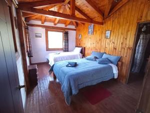 a bedroom with two beds in a wooden cabin at Taytapak Wasi in Riobamba