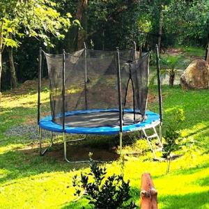 a trampoline in the middle of a yard at Villa Pella - Chalé Rosa- hidro e café manhã in Brumadinho