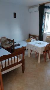a room with two beds and a table and chairs at Nada Rooms in Budva