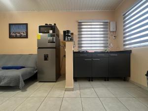 a kitchen with a refrigerator and a table in a room at Paradise Nest in Oranjestad