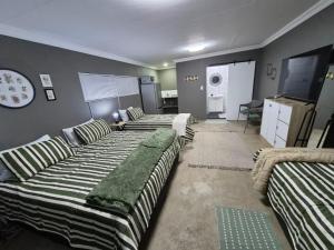 a living room with three couches and a tv at 42AtSouth in Vryheid +5 photos
