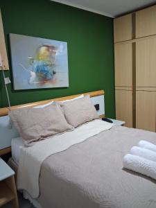 a bedroom with a white bed with a green wall at Apart Quartier Latin in Vitória
