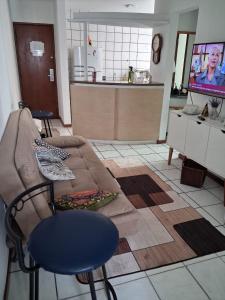a living room with a couch and a kitchen at Apart Quartier Latin in Vitória