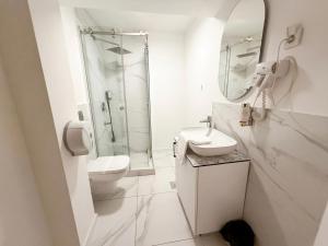 a white bathroom with a sink and a shower at Maison Mark Luxury Suites & Spa in Belgrade