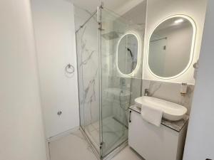 a bathroom with a glass shower and a sink at Maison Mark Luxury Suites & Spa in Belgrade