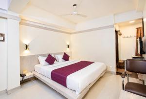 a bedroom with a large white bed with purple pillows at Hotel Hotel HVH Elite Kashi Vishwanath # Resturent and Free Wifi in Varanasi