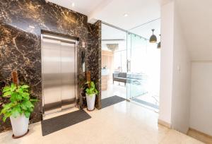 a lobby with a metal door and potted plants at Hotel Hotel HVH Elite Kashi Vishwanath # Resturent and Free Wifi in Varanasi