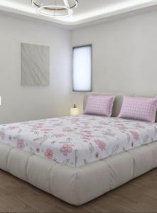 a large bed in a white room with pink flowers at बिश्नोई भवन in New Delhi