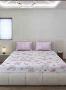 a white bedroom with a large bed with pink pillows at बिश्नोई भवन in New Delhi