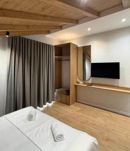 a hotel room with a bed and a flat screen tv at Airport Gate Hotel in Rinas