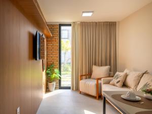 a living room with a couch and a tv at Villa 18 Atins Rooftop com piscina in Barreirinhas