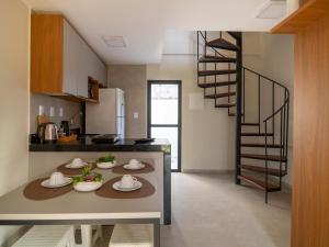 a kitchen with a table and a spiral staircase at Villa 18 Atins Rooftop com piscina in Barreirinhas