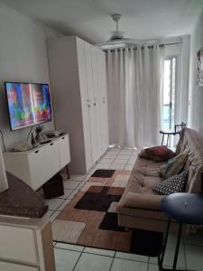 a living room with a couch and a flat screen tv at Apart Quartier Latin in Vitória