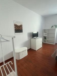 a white room with a desk and a television at Historic Charm Apartment Bayreuth in Bayreuth