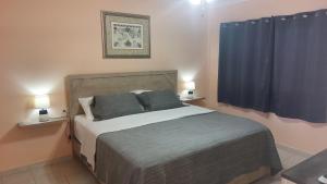 a bedroom with a bed with blue curtains and two lamps at Paradise Nest in Oranjestad