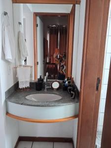 a bathroom with a sink and a mirror at Apart Quartier Latin in Vitória