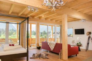 a living room with a couch and a chandelier at Boutiquehotel Berghof in Pertisau