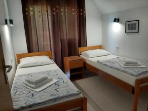 two beds in a small room with two towels at Domacinstvo Ubovic in Šipovo