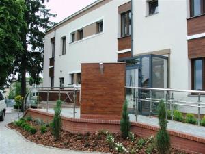 a large white building with a glass entry way at OW Viva in Jantar